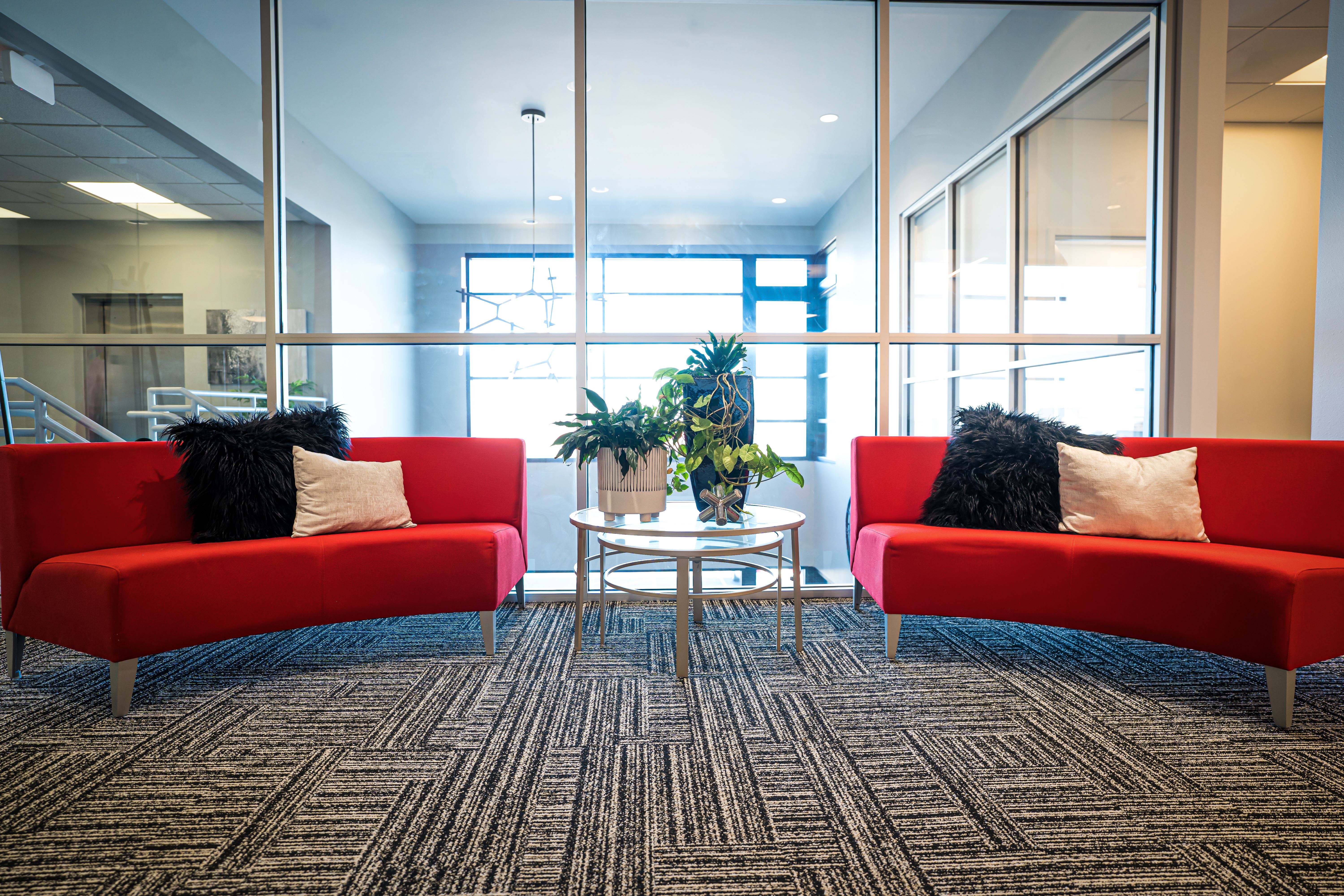 Image of two red lounge couches with a desk between them