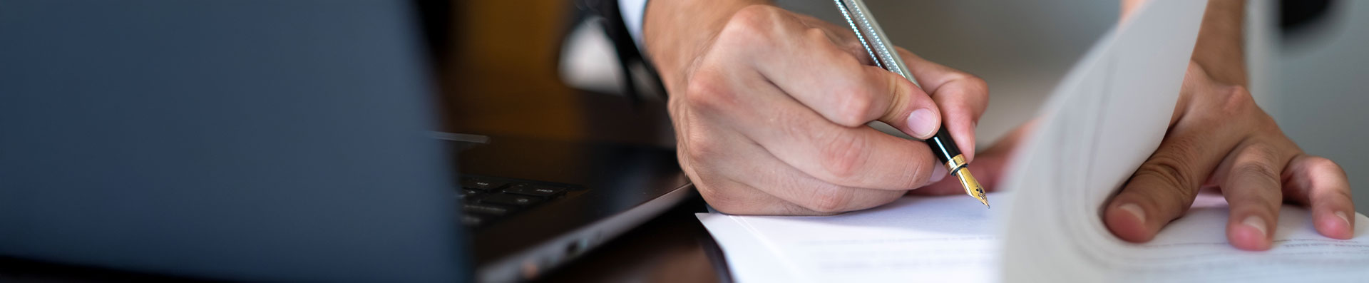Close up of hand writing on legal document
